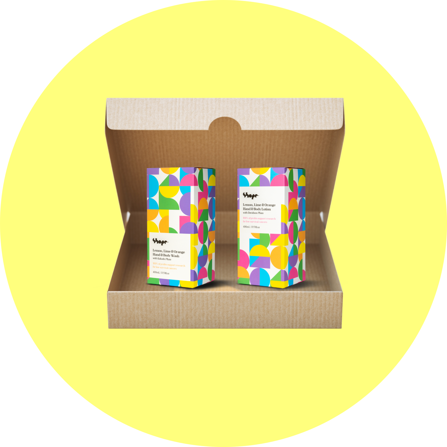 Boxed SHOPE lemon lime and orange hand and body wash and hand and body lotion, inside brown shipping box with yellow circle background.