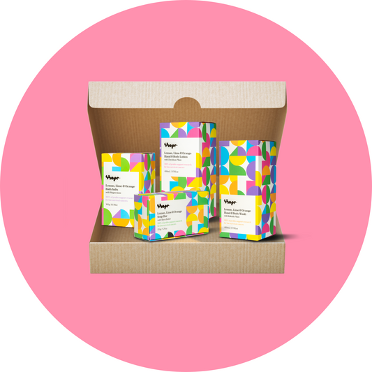 Boxed SHOPE lemon lime and orange suite of products, inside brown shipping box with pink circle background. Products include hand and body wash, hand and body lotion, bath salts and soap bar.